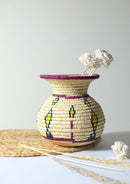 Sikki grass vase is kept on a table decorated with white flower