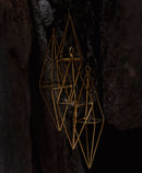 brass wind chime hanging in a cave