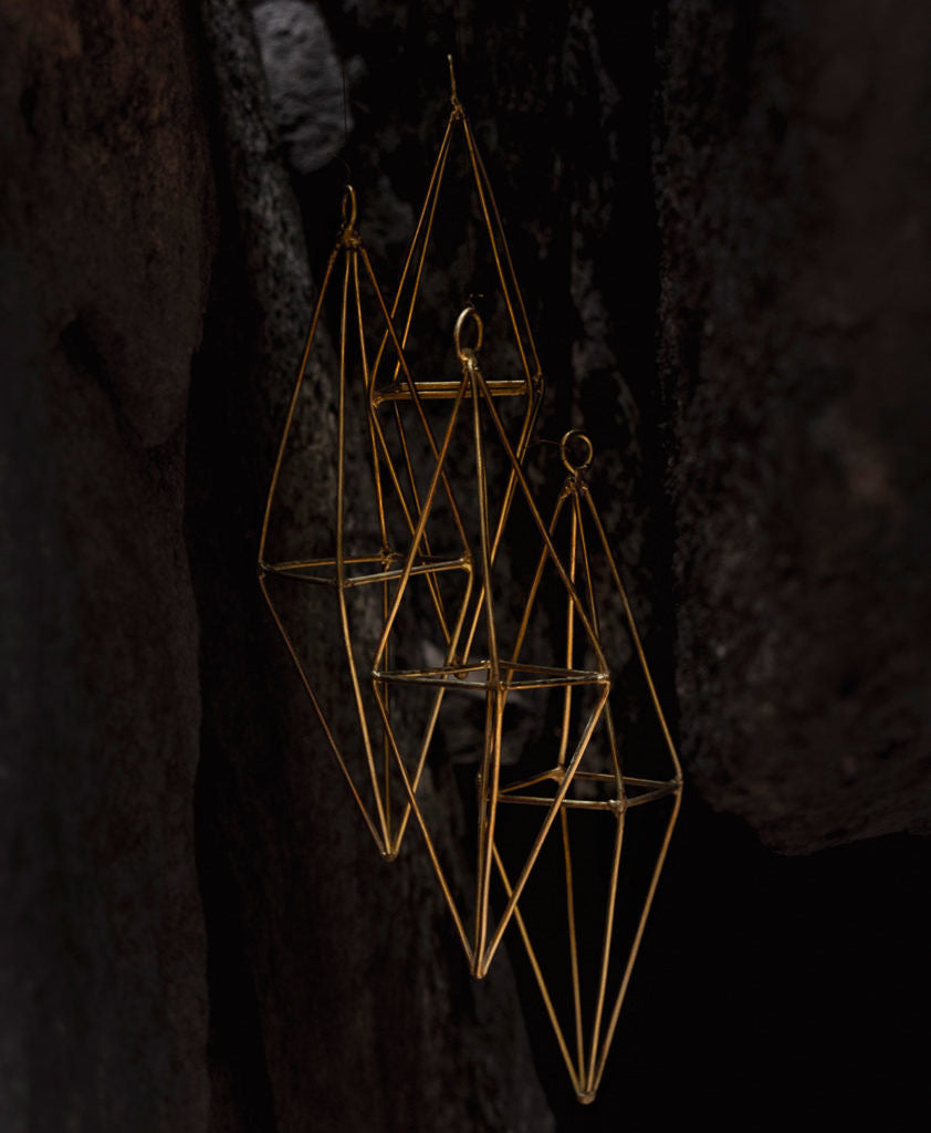 brass wind chime hanging in a cave