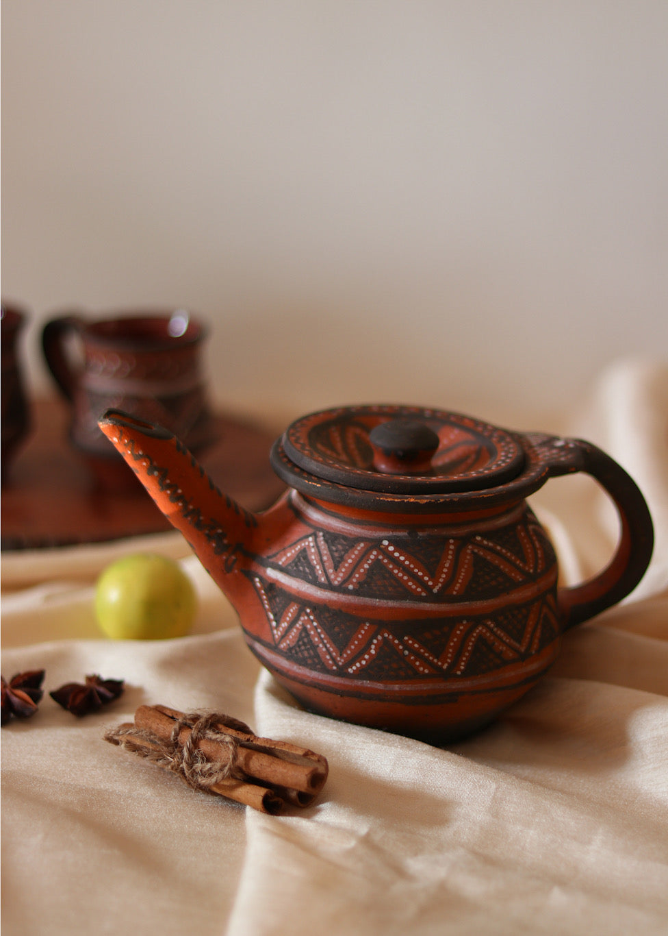 Red clay hand painted tea pot kept on the table