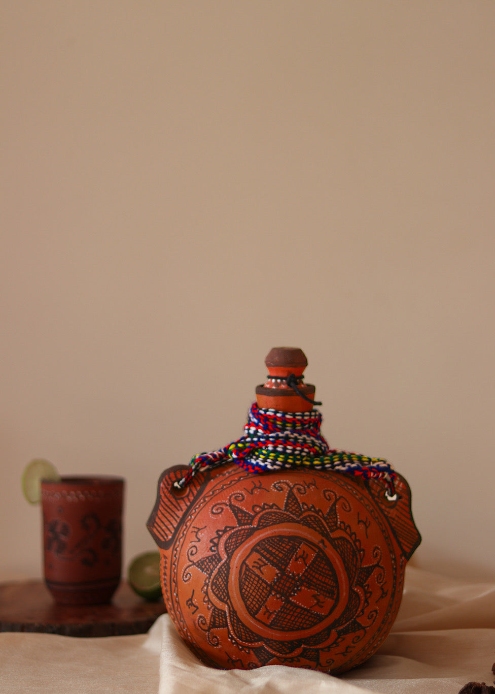 A red hand painted clay water bottle kept on the table