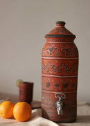 A red hand painted clay water dispenser kept on the table