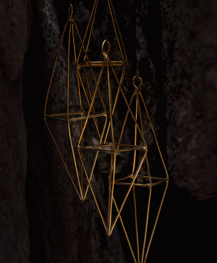 brass wind chime hanging in a cave