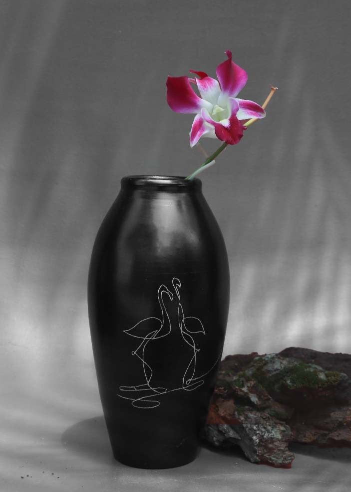 black clay vases with silver inlay motifs are kept on the table with purple flower decorated in it.