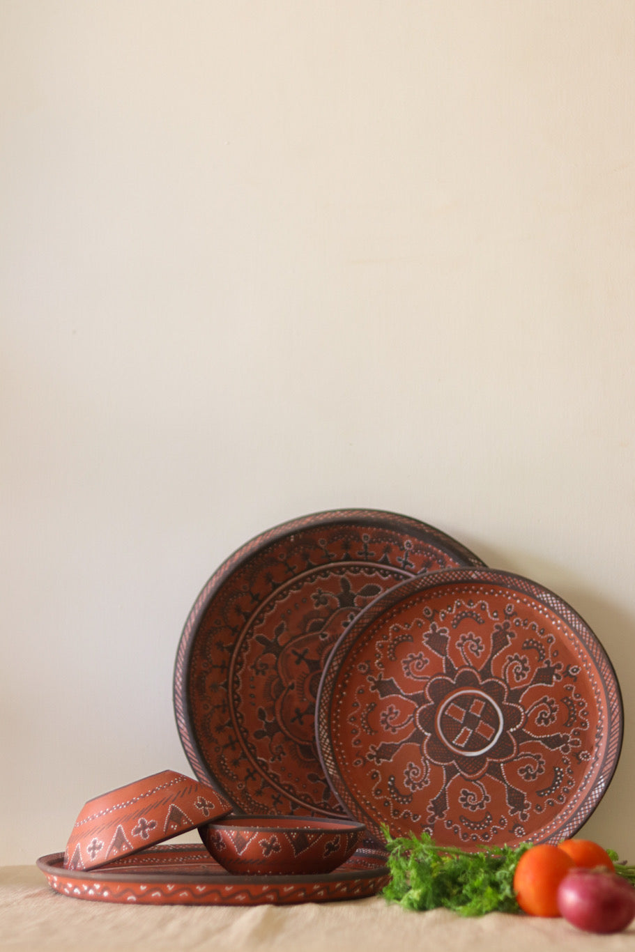 A red hand painted dinner set with plates kept on the table