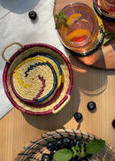 Sikki grass hand woven colourful tea coater set is kept on a table with glass of fruit juice