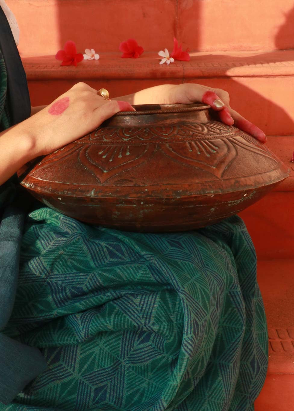 Copper embossed Vase on a woman's lap while she holds it