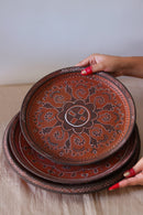 A red hand painted dinner set with plates kept on the table