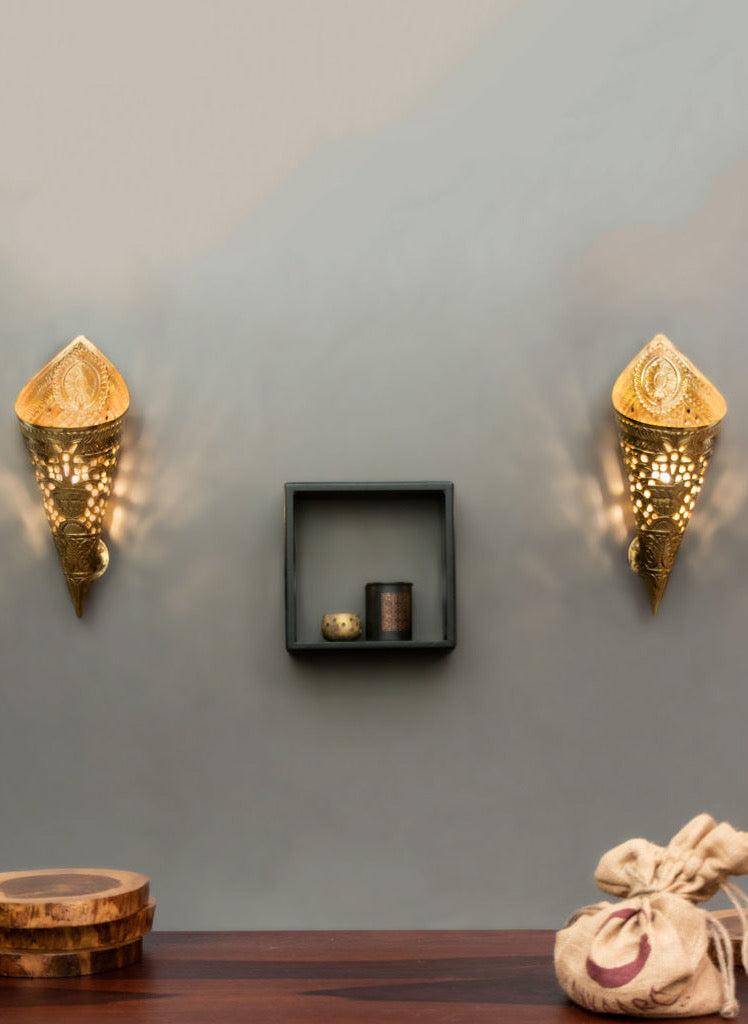 Brass embossed and cut out wall lights are hung on the wall