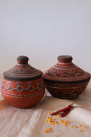 a couple of red hand painted pottery serving pots sitting on top of a table