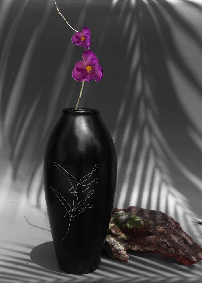 black clay vases with silver inlay motifs are kept on the table with purple flower decorated in it.