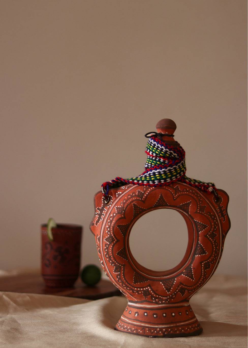 A red hand painted clay water bottle kept on the table