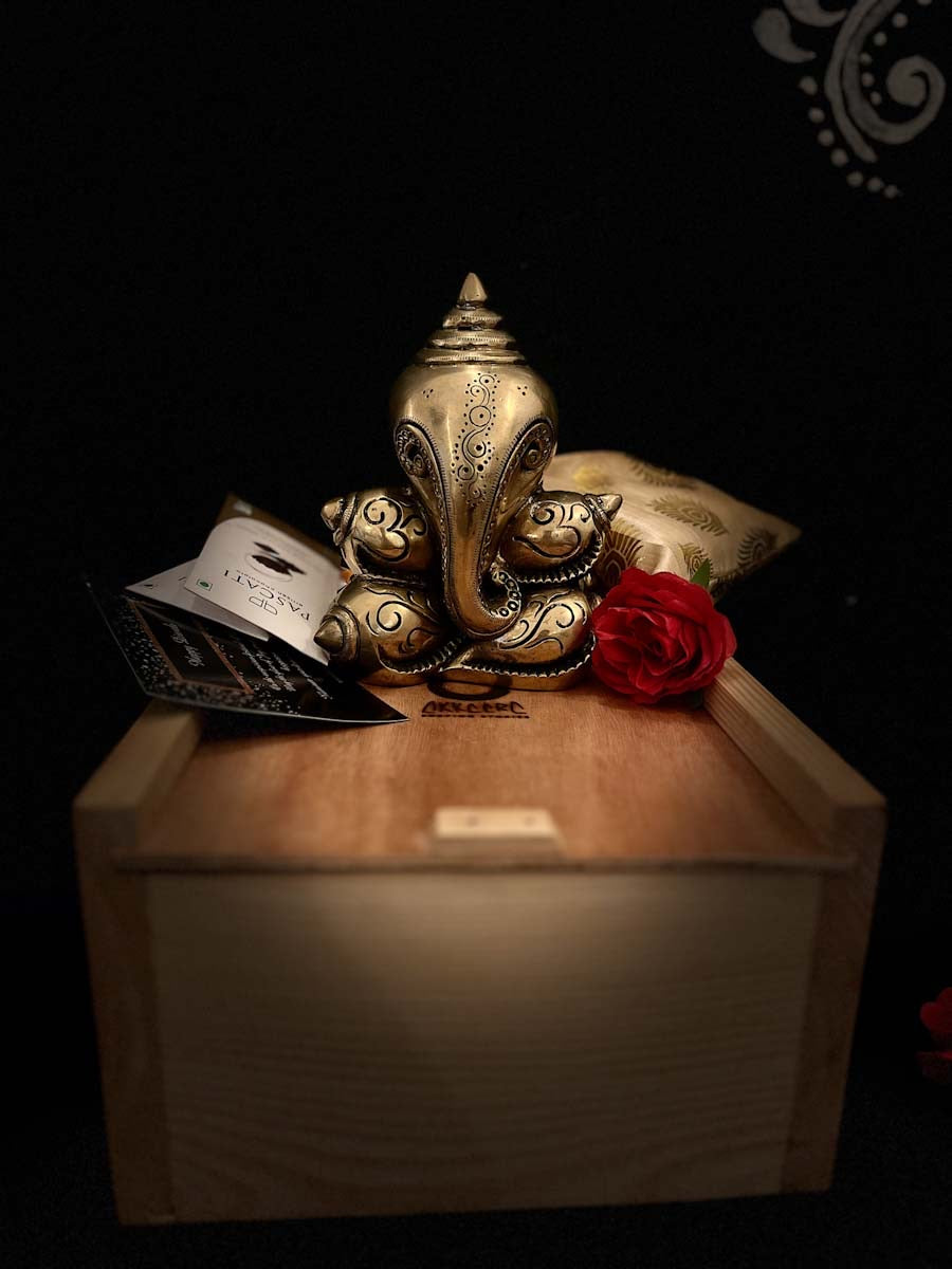 Brass engraved Shankh shaped lord Ganpati is kept on akkaara wooden gift box