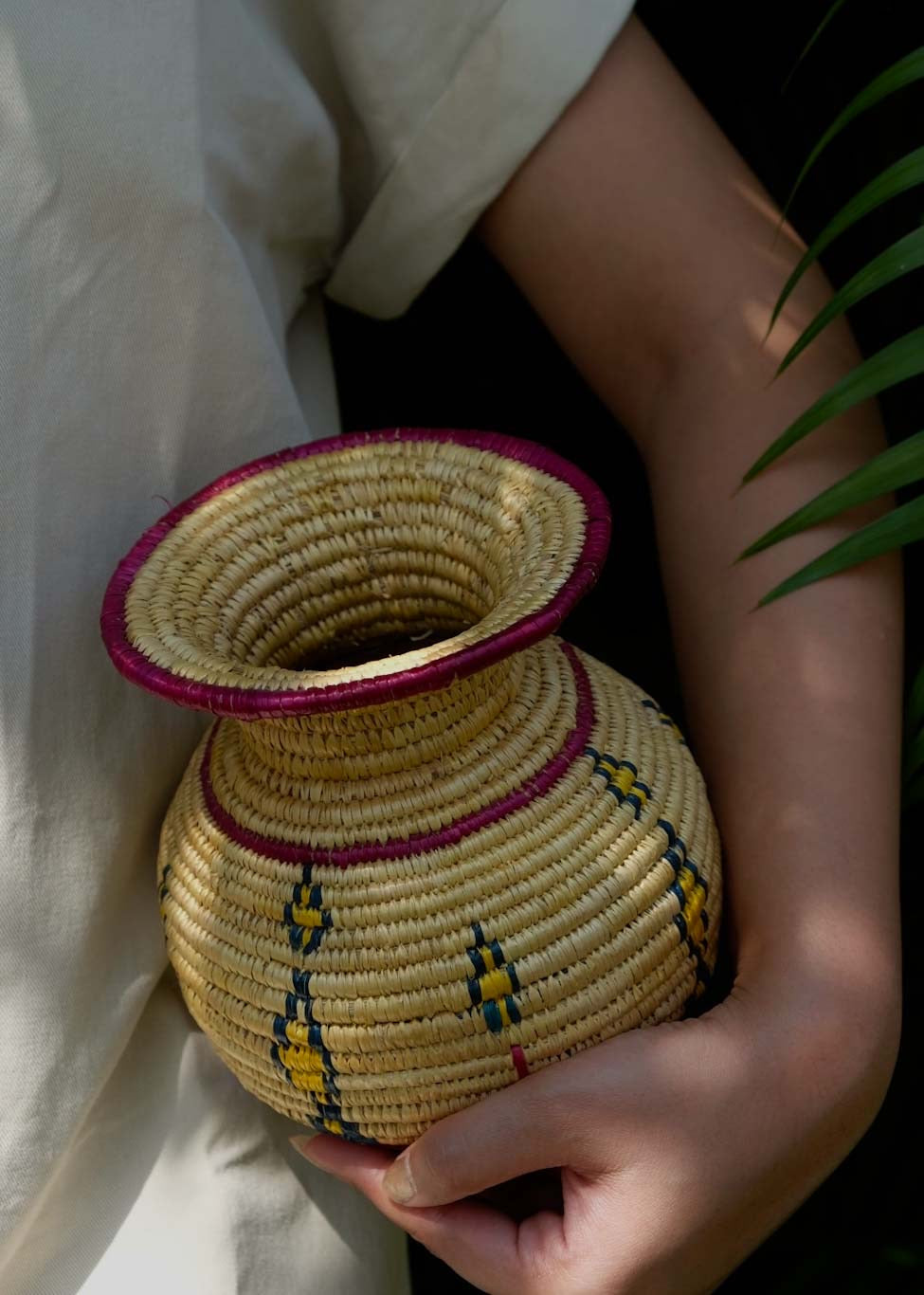 a girl is holding Sikki grass vase a garden