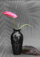 black clay vases with silver inlay motifs are kept on the table with red flower decorated in it.