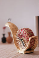 hand woven snail shaped table clock kept on table 