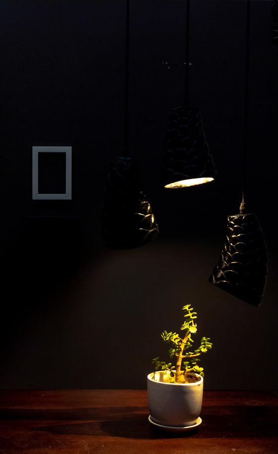 black stone sculpted pendant light is hanging above a table