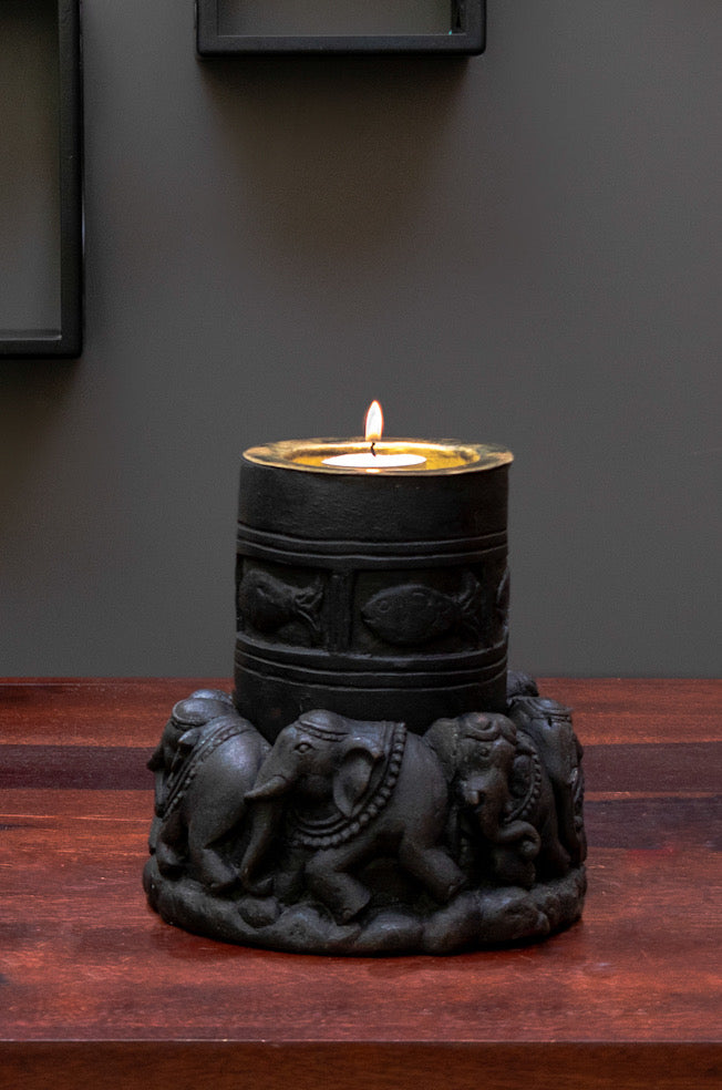 Black stone hand carved candle light in the shape of elephant is kept on a table